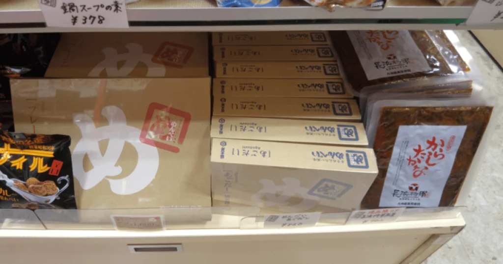 ザ・博多の棚に並ぶ「めんべい(あごだし・プレーン)」の箱と福岡名物「長浜将軍 からし高菜」
