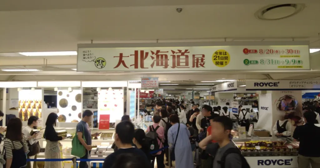 「大北海道展」の巨大な看板が掲げられた会場入口と、入場を待つ多くの来場者の様子。