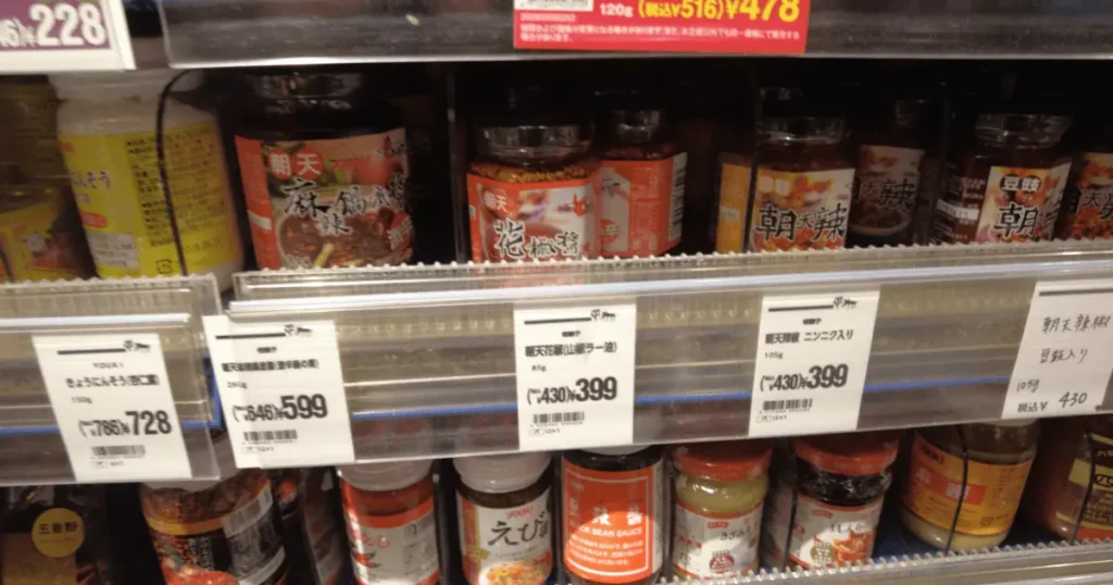カルディの中華調味料棚に並ぶ朝天花椒醤(山椒ラー油)と399円の価格表示POP