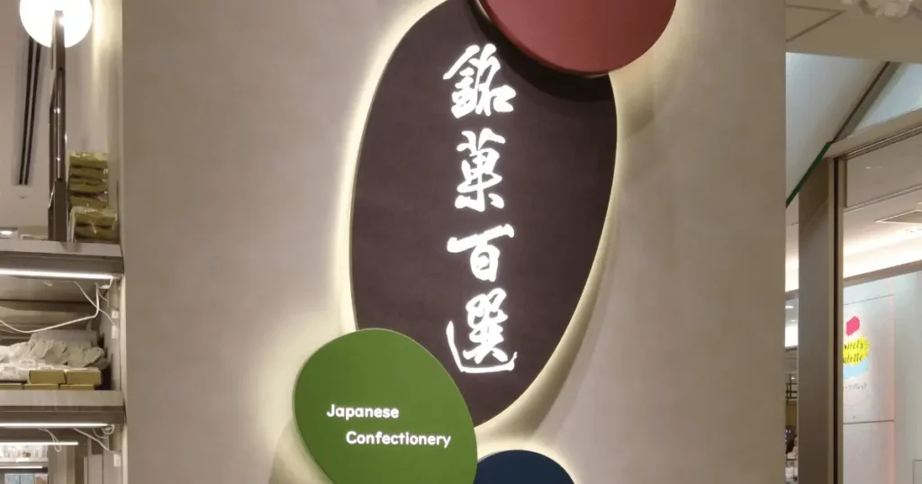 高島屋の全国銘菓売場「銘菓百選」の壁面看板とJapanese Confectioneryのロゴサイン