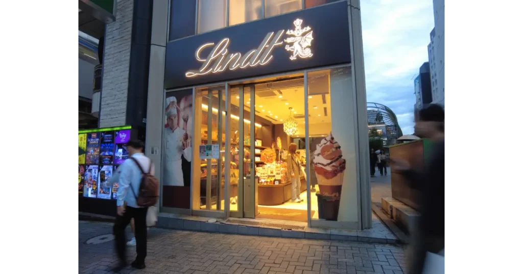 金色のブランドロゴが光るリンツ直営店の店舗外観と店頭入口
